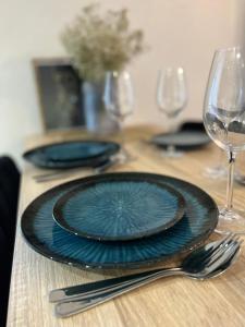 a table with a blue plate and glasses on it at Апартаменти центр Чортків in Chortkiv
