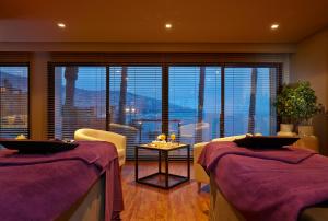 Cette chambre comprend deux lits et une grande fenêtre. dans l'établissement The Cliff Bay - PortoBay, à Funchal