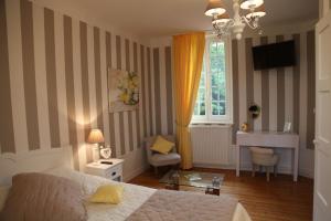 a bedroom with a bed and a desk and a window at La Bertonnerie en Champagne in Prunay