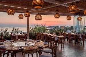 a restaurant with tables and chairs and a view of the ocean at Cap St Georges Villas in Peyia