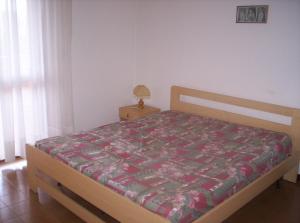 ein Schlafzimmer mit einem Bett mit einer Decke darauf in der Unterkunft Residence Libertà in Grado