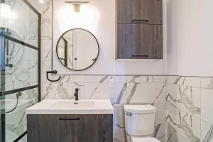 a bathroom with a sink and a mirror and a toilet at 201 Condo au rez de chaussée , au coeur de Bromont in Bromont +28 photos