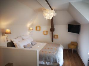 um quarto com uma grande cama branca e um lustre em La Bertonnerie en Champagne em Prunay
