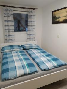 Una cama con dos almohadas azules y blancas. en Ferienwohnung Panoramablick, en Oberharmersbach