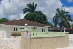 uma casa com uma vedação e um cartaz à frente dela em Budget & Basic in Local Neighborhood, 7min Drive to Downtown Nassau Beach Paradise em Nassau
