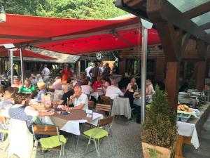 un grupo de personas sentadas en mesas en un restaurante en Waldrestaurant VIDA, en Kapfenberg