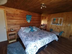 um quarto com uma cama num quarto de madeira em Cabañas Matanzas Lukai em Matanzas