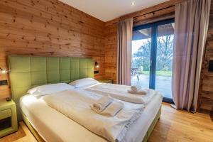 a bedroom with a large bed and a large window at Chalet Dinkel in Niedernsill in Niedernsill