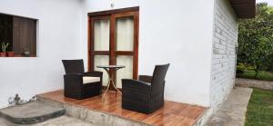 trzy krzesła i stół na ganku w obiekcie Fundo Don Ricardo w mieście Lima
