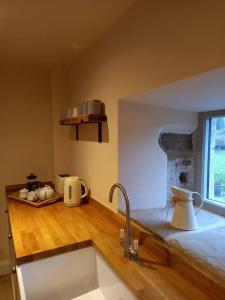eine Küche mit einer Spüle und einer hölzernen Arbeitsplatte in der Unterkunft Henry's Cottage in Skipton