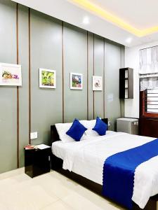 a bedroom with a large bed with blue pillows at Pearl Beach Homestay - Cua Dai Beach, Hoi An in Hoi An