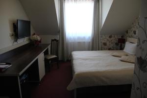 a hotel room with a bed and a desk and a window at Prymus in Radom