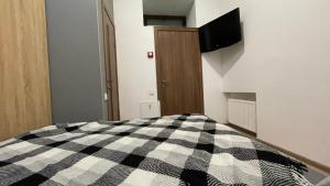 a bedroom with a black and white checkered bed at Кімнати в центрі з усіма зручностями та окремим входом in Ivano-Frankivsk