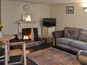 a living room with a couch and a fireplace at Blackberry Cottage in Kenton