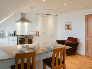 a kitchen with a table and chairs and a kitchen with a stove at Arc House in Cellardyke