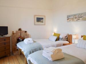 a room with three beds and a tv and a couch at Arc House in Cellardyke