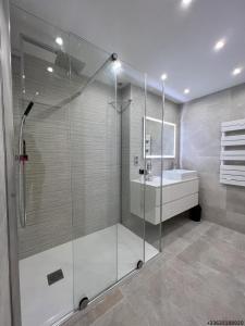 y baño con ducha de cristal y lavabo. en Magnifique appartement les pieds dans l’eau à Nice, en Saint-Laurent-du-Var