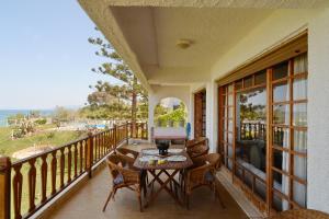porche con mesa y sillas en el balcón en Antorina Grande beachfront house, en Kamárion