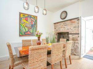 a dining room with a table and chairs and a fireplace at The Coach House At Vane Hill in Torquay