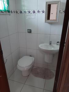 a bathroom with a toilet and a sink at Sobrado Em Matinhos Pr in Matinhos