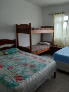 a bedroom with two bunk beds and a bed at Sobrado Em Matinhos Pr in Matinhos