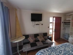 a living room with a couch and a tv on the wall at Cabañas Matanzas Lukai in Matanzas