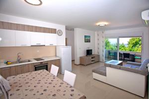 kuchnia i salon ze stołem i jadalnią w obiekcie Apartments Maslina III w mieście Nijvice