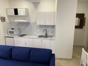 a living room with a blue couch and a kitchen at PETIT SAGASTA Apartamentos-Sagasta in Seville