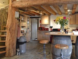 a kitchen with a table and a counter with stools at Meadow Barn in Ellingham