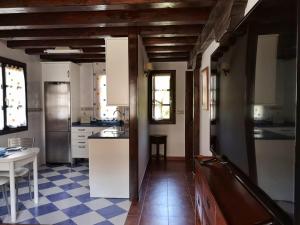 a kitchen with white cabinets and a checkered floor at LA CASA ROJA in Pechón