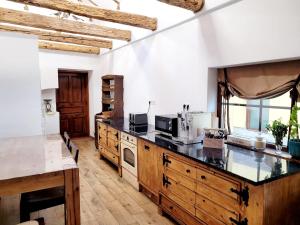 cocina con armarios de madera y encimera en Joyard - Pensiune & Parc en Porumbacu de Sus