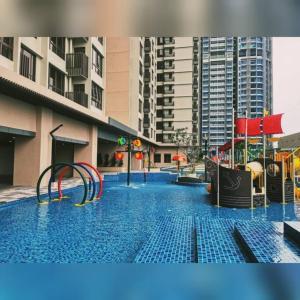 a swimming pool with a playground in a city at D'RZ Muslim Seaview Homestay Bali Residence in Melaka