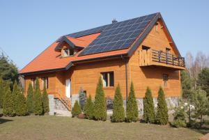 ein Haus mit Sonnenkollektoren auf dem Dach in der Unterkunft Gościniec u Zalesia Warchały Noclegi Zalewski in Warchały