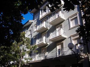 a white building with balconies on the side of it at Europa Unita Apartment in Grado