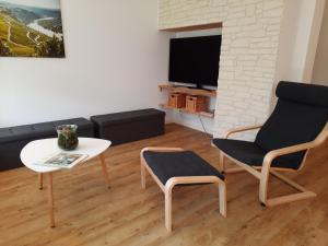 een woonkamer met een bank, een tafel en een stoel bij Ferienhaus Moselglück - kostenlose ÖPNV-Nutzung inbegriffen in Bernkastel-Kues