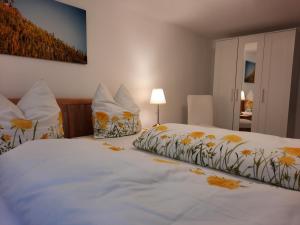 sypialnia z dużym białym łóżkiem z żółtymi kwiatami w obiekcie Ferienhaus Moselglück - kostenlose ÖPNV-Nutzung inbegriffen w mieście Bernkastel-Kues