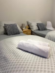 a bed with a white towel on top of it at Nowa Biała Apartament - domek na wyłączność in Nowa Biała