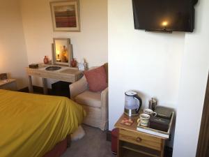 a bedroom with a bed and a desk with a sink at NIGHTINGALE B&B in Pershore