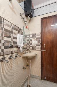 a bathroom with a sink and a wooden door at (TF) Entire Indpndnt Private 2 BHK Flat,Nr Airport in New Delhi