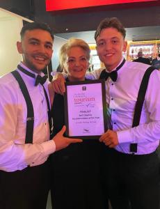 two men and a woman holding a framed award at Lincoln Holiday Retreat Cottage with Private Hot Tub in Lincoln