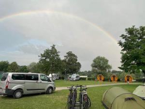 een busje geparkeerd in een veld met fietsen en tenten bij Donaucamping Emmersdorf in Emmersdorf an der Donau