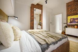 a bedroom with a bed and a brick wall at Modern Symphony - Stunning Central Apartment in Bucharest