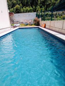 uma piscina com água azul num quintal em Magníficos Dias Atlânticos em Moledo