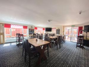 - une salle à manger avec des tables, des chaises et des fenêtres dans l'établissement Uk40237 - Beach Bank Bungalow, à Lympne