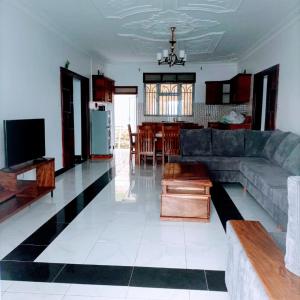 a living room with a couch and a kitchen at Villa Bunyonyi in Kabale