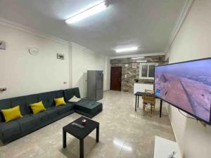 a living room with a couch and a large flat screen tv at New Cairo Luxury Apartment in luxury villa basement in Cairo