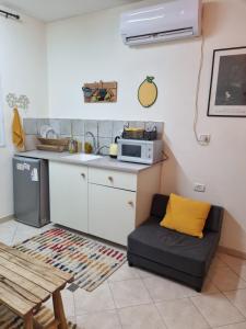 cocina con sofá y microondas en סוויטת פינת השקד en Rosh Pinna