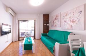 a living room with a green couch and a table at Piso Mirta Santa Cruz Tenerife in Santa Cruz de Tenerife