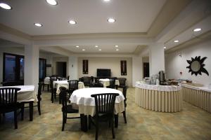 un restaurante con mesas y sillas con mantel blanco en Sun Accommodation, en Skopelos Town