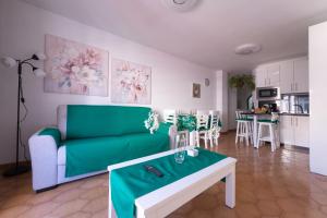 a living room with a green couch and a table at Piso Mirta Santa Cruz Tenerife in Santa Cruz de Tenerife